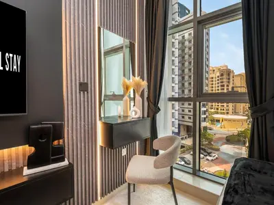 a room with a chair and a large window at Wonderful Stay at 7 Palm - Rooftop Infinity Pool - Direct Beach Access - Brand New Luxury Apartments in Dubai
