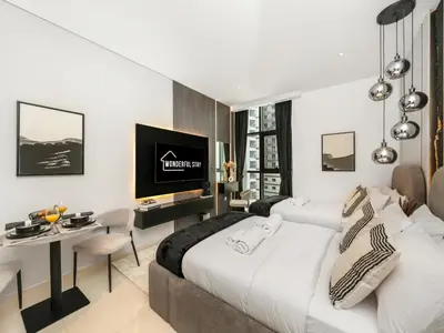 a bedroom with a bed and a desk and a tv at Wonderful Stay at 7 Palm - Rooftop Infinity Pool - Direct Beach Access - Brand New Luxury Apartments in Dubai