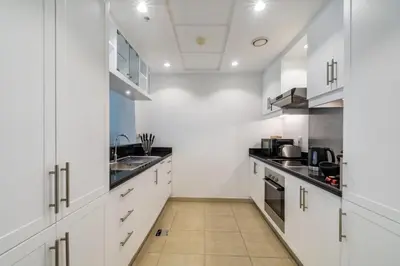 a kitchen with white cabinets and a sink at GlobalStay The Residences Tower 1 Apartments Downtown Dubai in Dubai