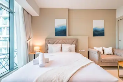 a bedroom with a large bed and a couch at Upgraded LUX Infinity Pool with Beach Access in Dubai