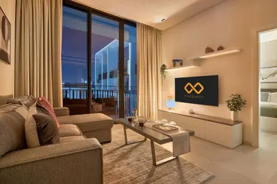 a living room with a couch and a tv at Elegant Apartment near Miracle Garden with Pool & Gym Access in Dubai