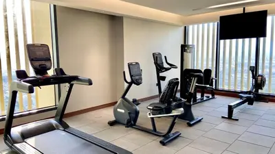 a gym with several tread machines in a room at Bright, Breezy and Central 1BR with Extra Room in Dubai