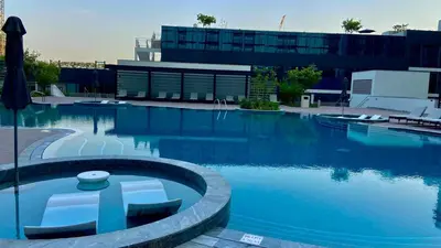a large swimming pool in front of a building at Bright, Breezy and Central 1BR with Extra Room in Dubai