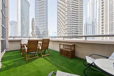 a balcony with chairs and a table with a view of the city at Boema Apartments - Terrace with Stunning Burj View in Dubai