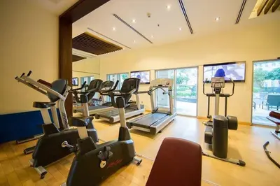 a gym with treadmills and ellipticals in a room at Boema Apartments - Terrace with Stunning Burj View in Dubai