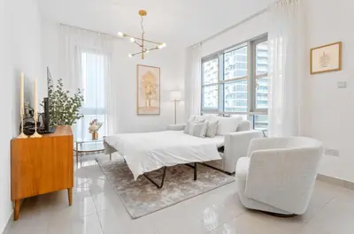 a white living room with a table and chairs at Boema Apartments - Terrace with Stunning Burj View in Dubai