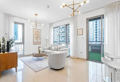 a living room with white furniture and large windows at Boema Apartments - Terrace with Stunning Burj View in Dubai