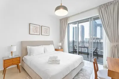 a bedroom with a bed and a large window at Boema Apartments - Terrace with Stunning Burj View in Dubai
