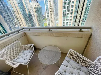a balcony with two chairs and a table and some buildings at 2BR apartment in the Heart of Downtown Dubai with Burj Khalifa View by Norbu Holiday Homes in Dubai