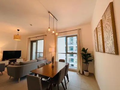 a living room with a table and a couch and a television at 2BR apartment in the Heart of Downtown Dubai with Burj Khalifa View by Norbu Holiday Homes in Dubai