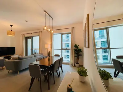 a living room with a dining table and a couch at 2BR apartment in the Heart of Downtown Dubai with Burj Khalifa View by Norbu Holiday Homes in Dubai