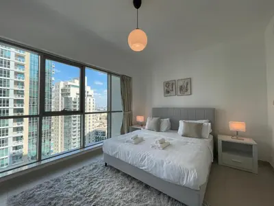 a bedroom with a large white bed and large windows at 2BR apartment in the Heart of Downtown Dubai with Burj Khalifa View by Norbu Holiday Homes in Dubai