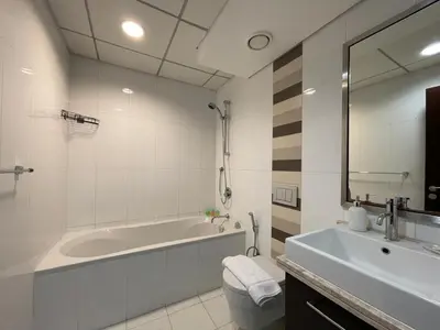 a white bathroom with a tub and a sink at 2BR apartment in the Heart of Downtown Dubai with Burj Khalifa View by Norbu Holiday Homes in Dubai