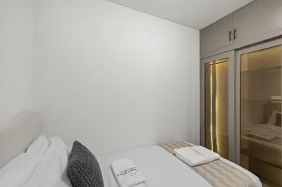 a white room with a bed with towels on it at Premium Stay in Sobha 1BR with Extra Room and Balcony in Dubai