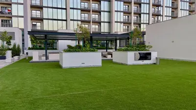 a large building with a lawn in front of it at Premium Stay in Sobha 1BR with Extra Room and Balcony in Dubai