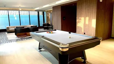 a living room with a pool table in a room at Premium Stay in Sobha 1BR with Extra Room and Balcony in Dubai