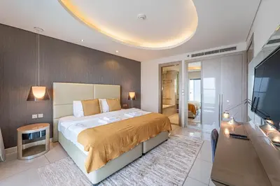 a bedroom with a large bed and a flat screen tv at Stylish Stay - 1 Bedroom - High Floor in Dubai