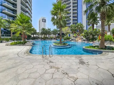 a swimming pool with palm trees in a city at Stylish Stay - 1 Bedroom - High Floor in Dubai