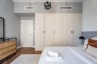 a bedroom with white cabinets and a large bed at GuestReady - 2BR | JBR Beach Stay | Canal View in Dubai