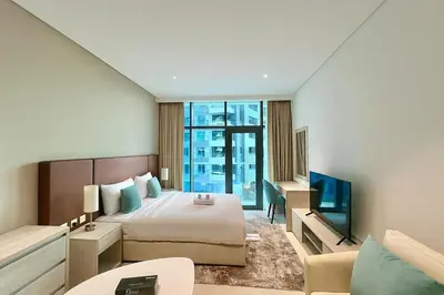 a hotel room with a bed and a television at LUX Infinity Pool with GYM, Private Beach Studio in Dubai