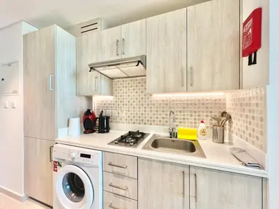 a kitchen with a sink and a washing machine at LUX Infinity Pool, Gym, Beach, Parking Studio in Dubai