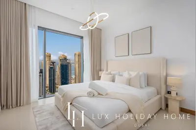a bedroom with a white bed with a large window at LUX The Vida Marina Residence in Dubai