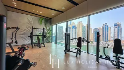 a gym with cardio equipment and a view of the city at LUX The Vida Marina Residence in Dubai