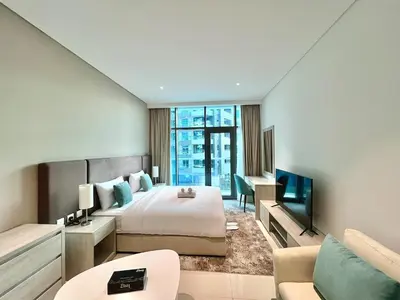 a hotel room with a bed and a desk and a tv at LUX Infinity Pool, Private Beach, GYM, Parking in Dubai