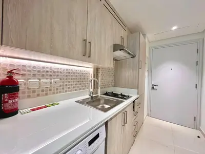 a small kitchen with a sink and a stove at LUX Infinity Pool, Private Beach, GYM, Parking in Dubai