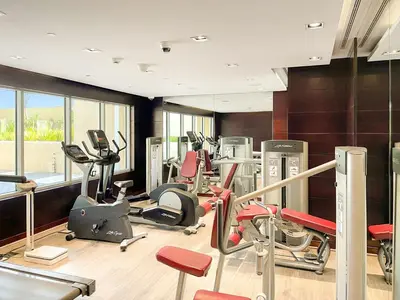a gym with several treadmills and exercise bikes at FIRST CLASS Studio Cozy Elegance in Dubai