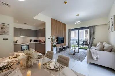 a kitchen and living room with a table and a couch at Act One Luxury 2BR Front-Row Burj & Fountain Views in Dubai