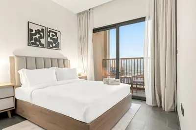 a bedroom with a white bed and a large window at FIRST CLASS 2BR Bright and Elegant Living in Dubai