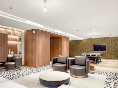 a lobby with chairs and a table and a pool table at FIRST CLASS 2BR Bright and Elegant Living in Dubai