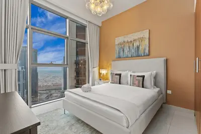 a bedroom with a large bed and a large window at FIRST CLASS 2BR Luxury Living in Downtown in Dubai