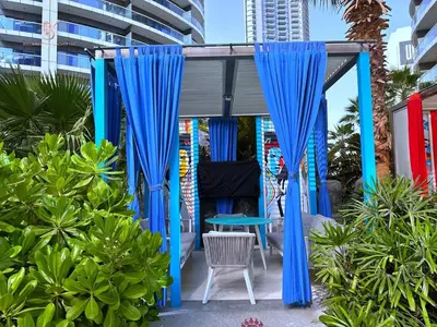 a gazebo with blue curtains and a table and a chair at Your Hollywood-Style Hideaway -DAMAC Paramount in Dubai