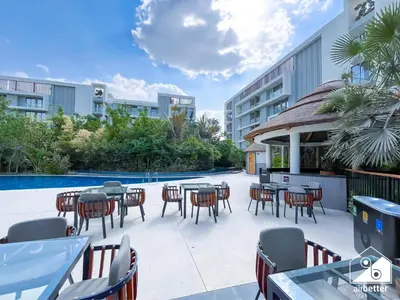a patio with tables and chairs next to a pool at Luxury 1BR Escape, Resort-Style Living in Dubai in Dubai