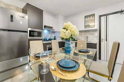 a dining room with a glass table and chairs at FIRST CLASS 2BR Chic Getaway Close to Metro in Dubai