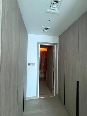 a hallway with a hallway leading to a room with a door at Modern 1BR with city views large space in Dubai