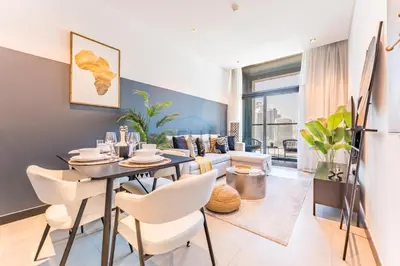 a dining room with a table and chairs and a couch at Burj Khalifa and Dubai Canal Views, Minutes from Downtown Dubai, Convenient Metro Access - 15 Northside Tower 2, Business Bay by Deluxe Holiday Homes in Dubai