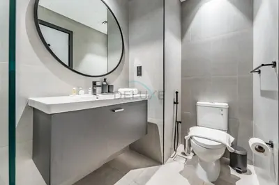 a bathroom with a sink and a mirror and a toilet at Burj Khalifa and Dubai Canal Views, Minutes from Downtown Dubai, Convenient Metro Access - 15 Northside Tower 2, Business Bay by Deluxe Holiday Homes in Dubai