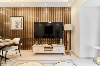 a living room with a large television and a table at FAM Living Elite Residence 1BR Walk to JBR Beach in Dubai