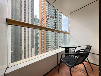 a table and chair on a balcony with a view of buildings at FAM Living Elite Residence 1BR Walk to JBR Beach in Dubai
