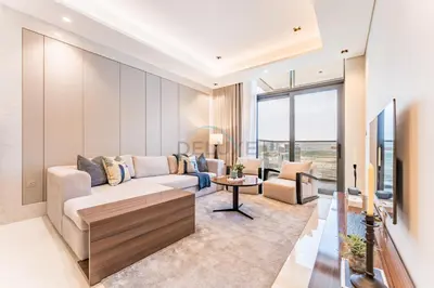 a living room with a couch and a tv at Spacious High-Floor 2BR with Stunning City and Burj Khalifa Views, Quick Drive to Downtown, and Steps from the Bus Station, Nobles, Business Bay by Deluxe Holiday Homes in Dubai