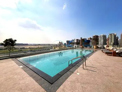 a large swimming pool on top of a building at Spacious High-Floor 2BR with Stunning City and Burj Khalifa Views, Quick Drive to Downtown, and Steps from the Bus Station, Nobles, Business Bay by Deluxe Holiday Homes in Dubai