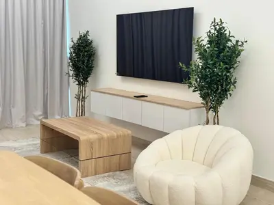 a living room with a chair and a tv at Stylish One Bed Apartment near Downtown in Dubai