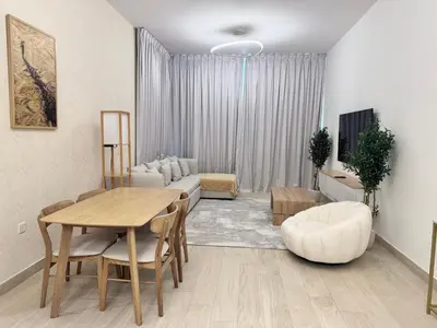 a living room with a couch and a table and chairs at Stylish One Bed Apartment near Downtown in Dubai