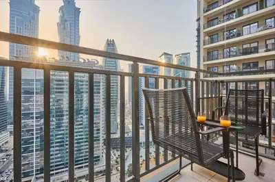 a balcony with a chair and a view of the city at Stylish 1BR Apartment, ZADA Tower with Pool & Gym, Business Bay in Dubai