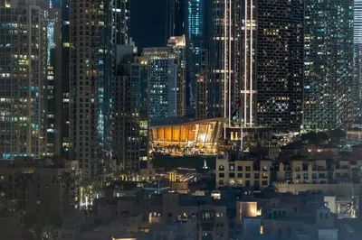 a city lit up at night with tall buildings at DAMAC MAISON DISTINCTION - Burj Khalifa View, Fee Parking in Dubai