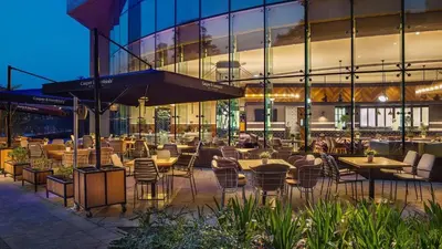 a restaurant with tables and chairs in front of a building at DAMAC MAISON DISTINCTION - Burj Khalifa View, Fee Parking in Dubai
