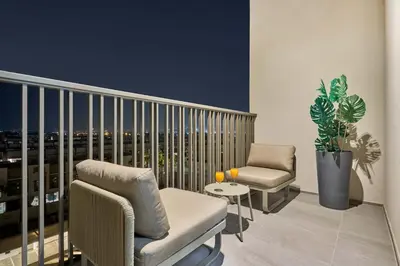 a balcony with two chairs and a table at New Studio Apartment, MAG 910 - Dubai Stay in Dubai